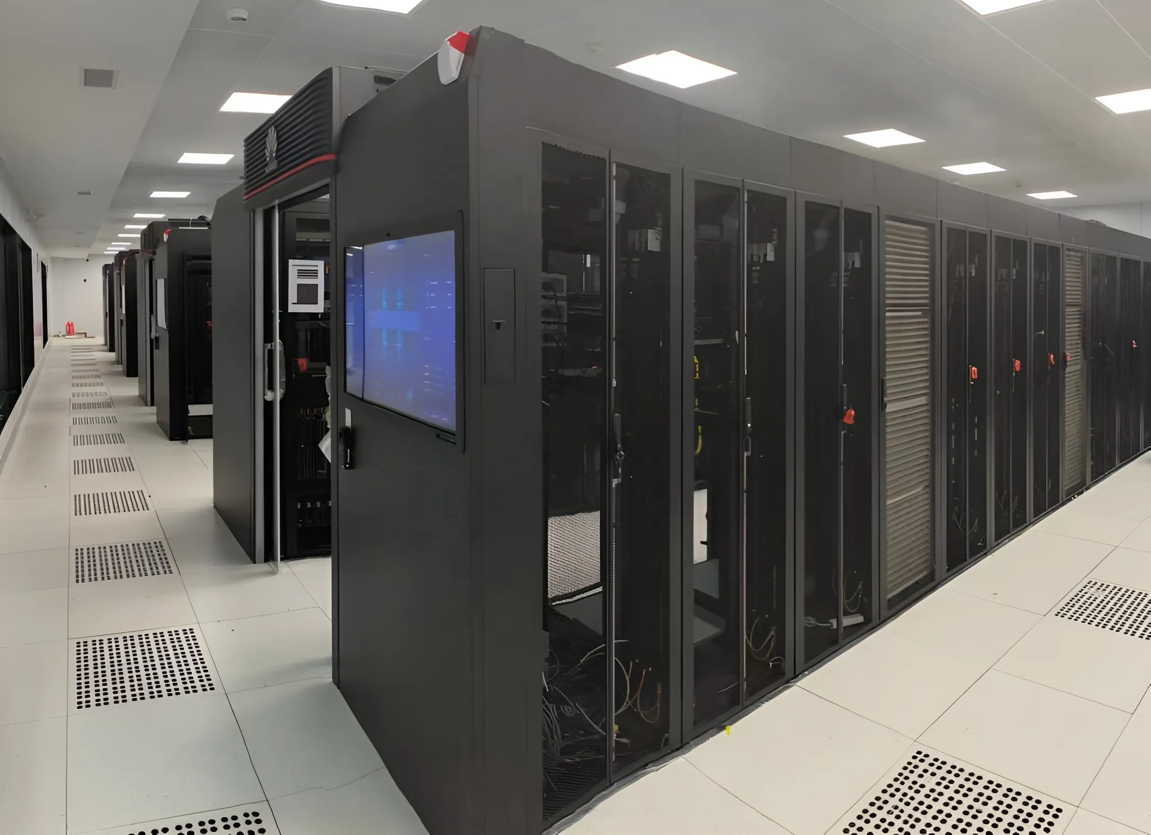 Enclosed aisle of liquid-cooled server cabinets on a raised floor.
